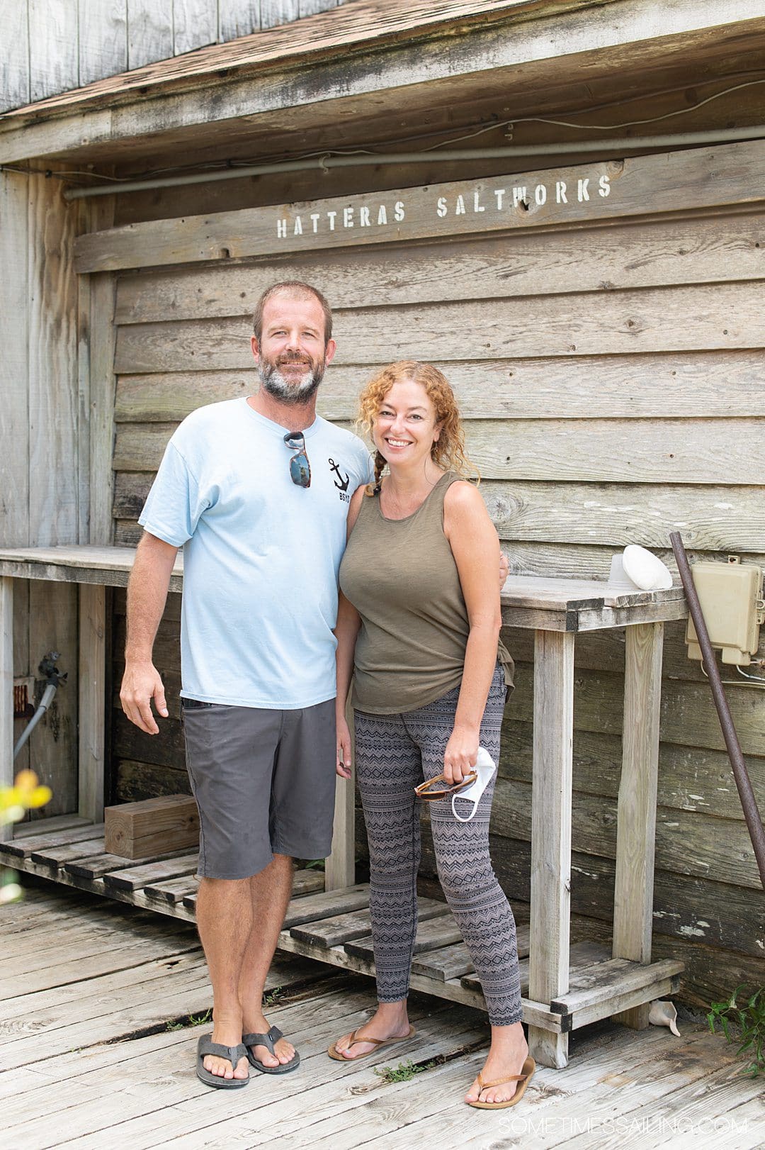 A man and woman in front of a wood wall that says "Hatteras Saltworks"