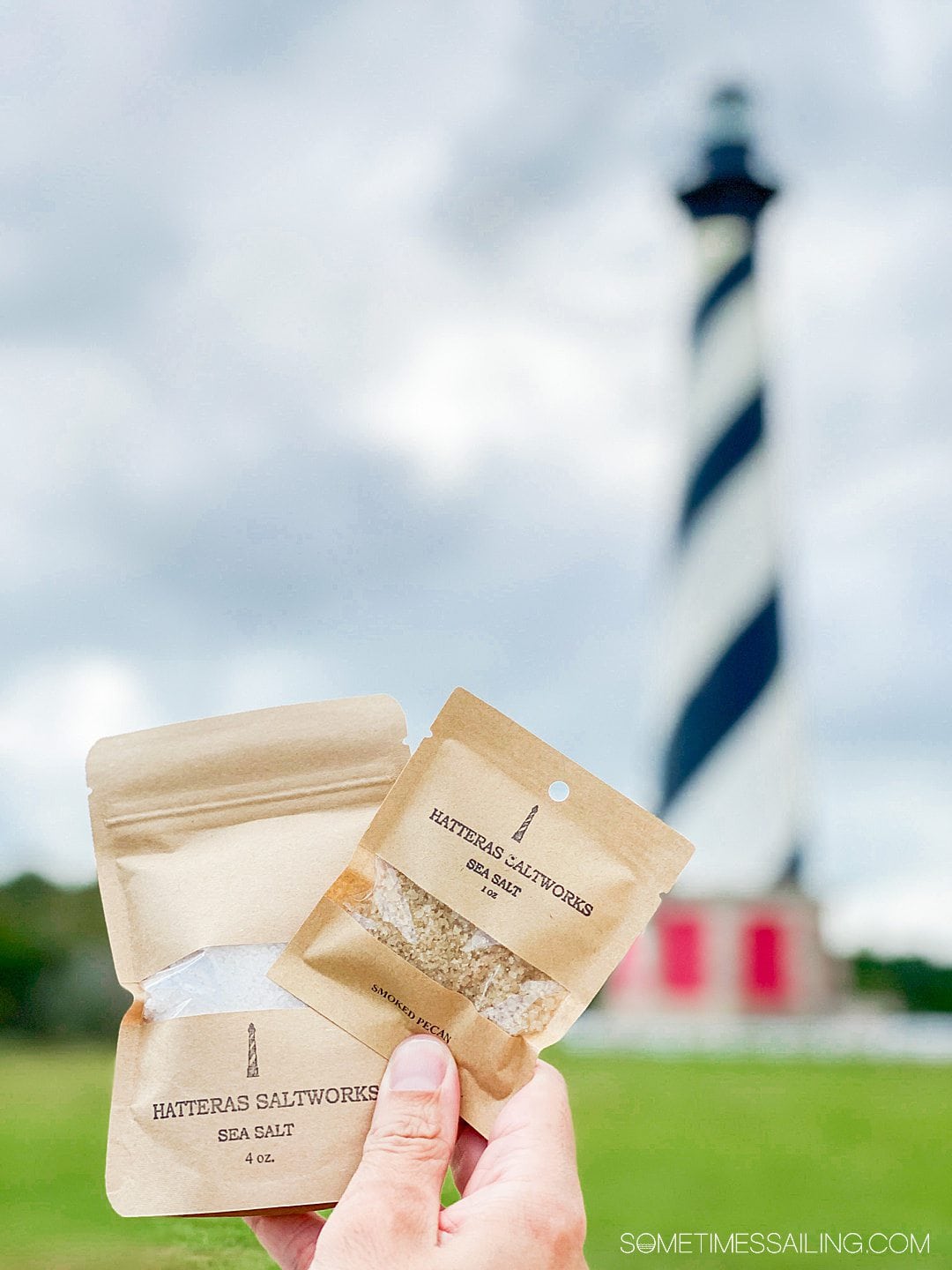 Two packages of Hatteras Saltworks in kraft paper packaging with a lighthouse in the background.