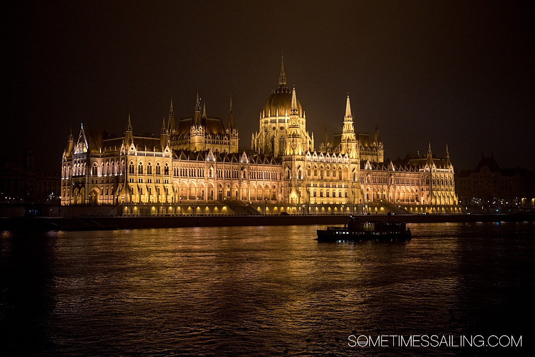 Parliament building in Budapest at night time, illuminated by lights for a Christmas Markets River Cruise post.