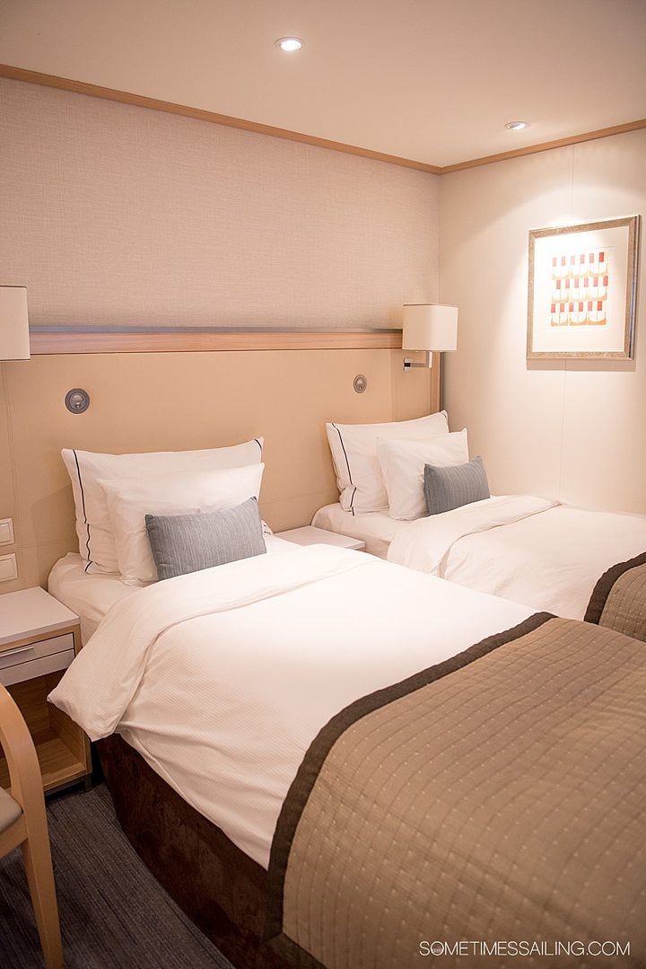Two twin beds inside a stateroom onboard a Viking river cruise ship.