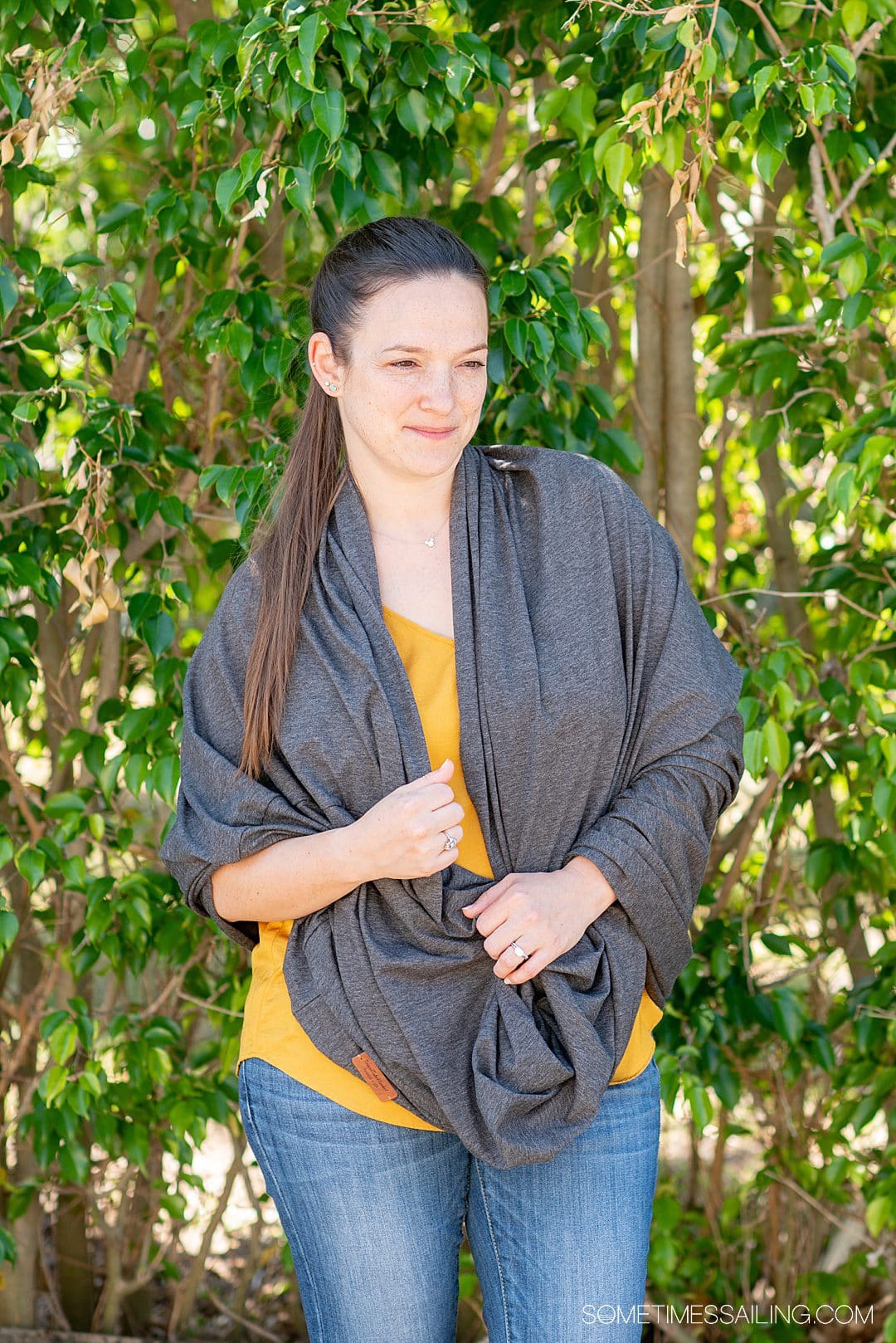 Woman in a yellow shirt with a grey shawl on.