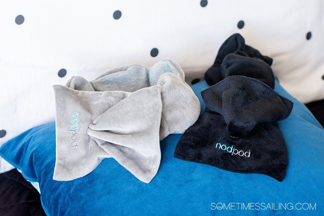 nodpod weight sleep masks in grey and black on top of a blue pillow.