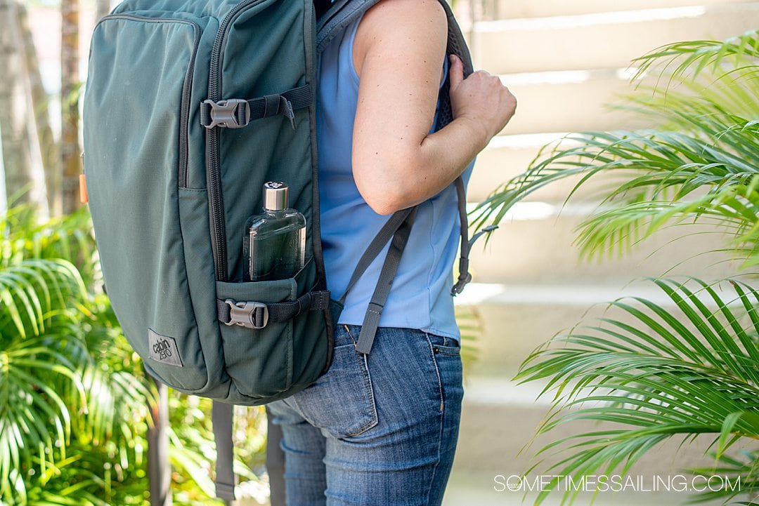 Moss green backpack with a reusable water bottle on the right side.