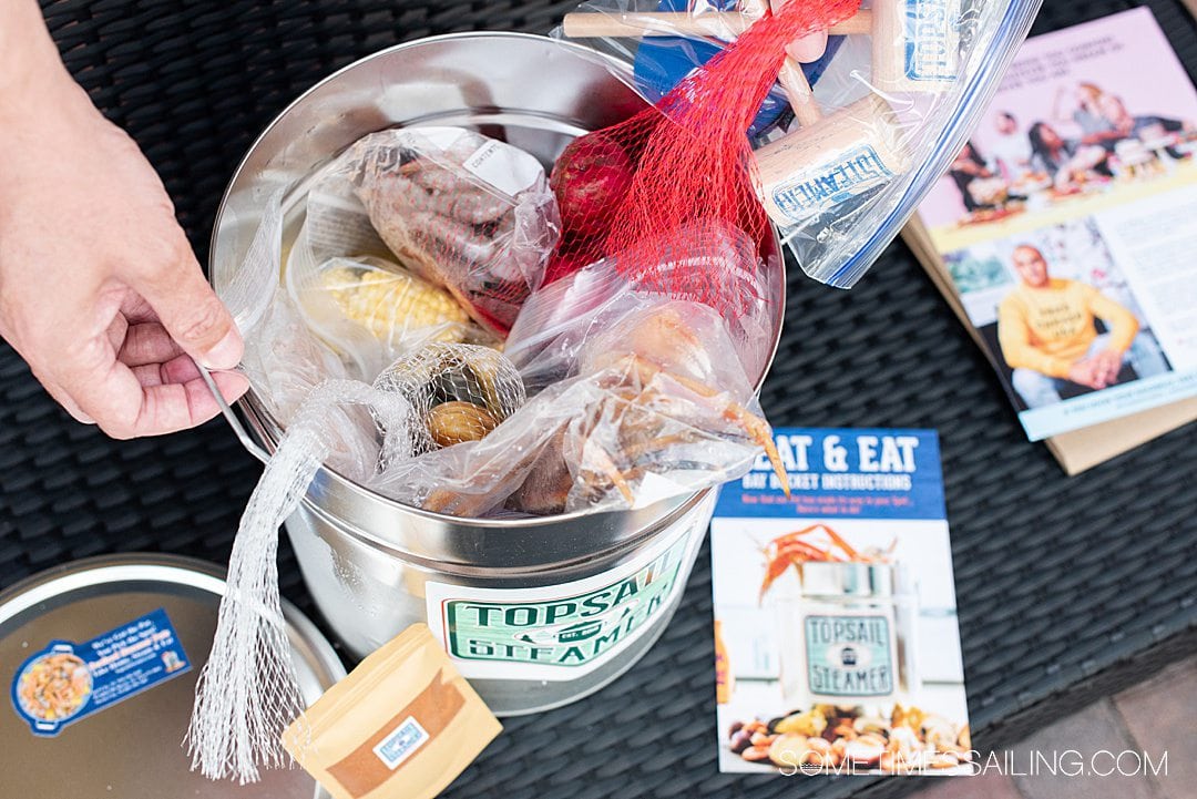 Contents of a seafood steamer pot for a Topsail Steamer review, with seafood, corn and potatoes inside in plastic bags.