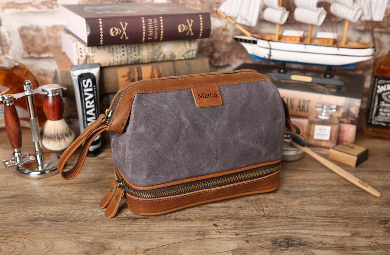 Brown leather and blue canvas toiletry bag with personalization for cruise gift ideas.