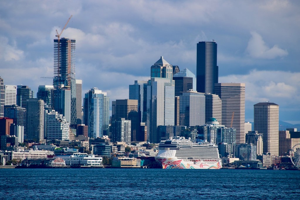 Cruise ship in the water with the Seattle, Washington skyline behind it.