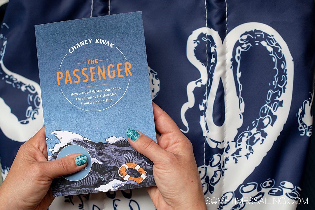 Book The Passenger with a blue cover, held in front of a bag with octopus tentacles for a post about non-fiction cruise books.