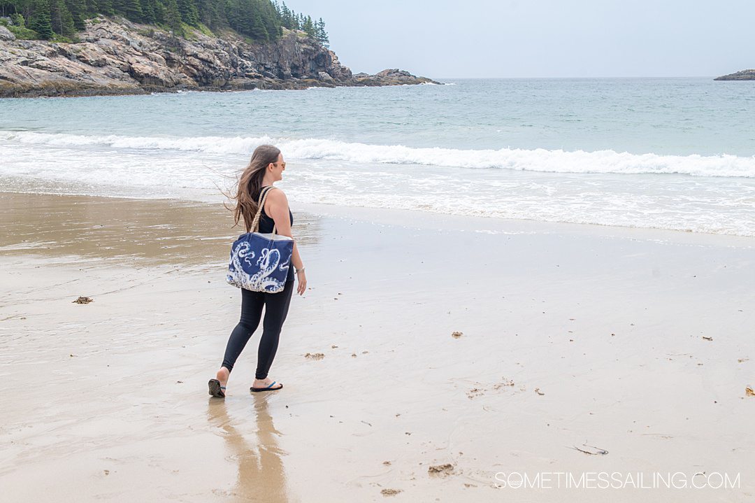 Woman on a beach with an octopus pattern beach bag.