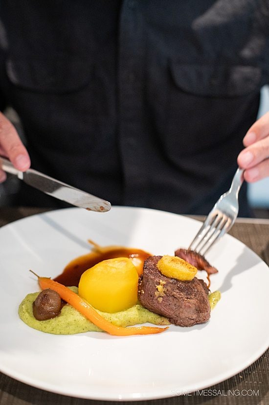 Man cutting filet and potatoes, with a carrot and veggie puree on Emerald Destiny for a river cruise food entree option.