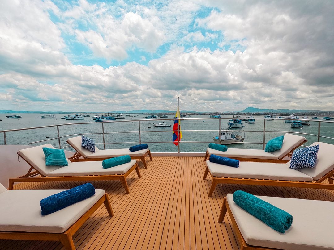 Exterior aft of Kontiki Expeditions yacht cruise ship with lounge chairs on a wooden deck.
