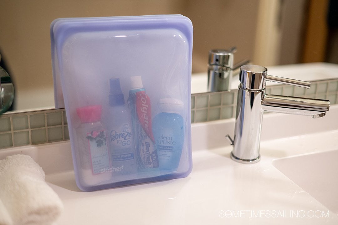 Purple silicone reusable Stasher Bag on a sink on a cruise ship, next to a silver faucet.