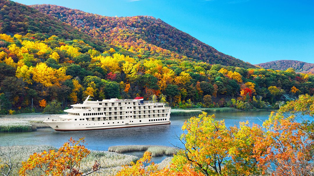 American Constitution ship on a US River cruise amongst fall foliage.