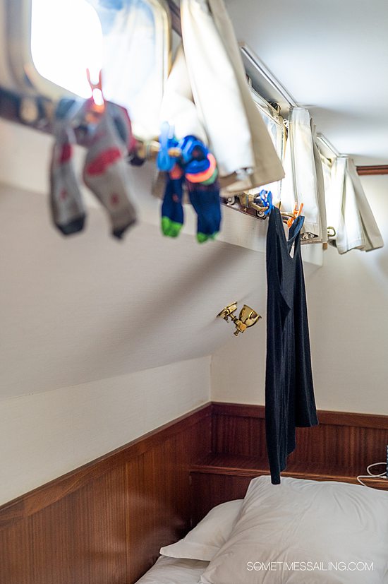 Clothes handing from a small window attached with clothespins, which should be on a barge cruise packing list.