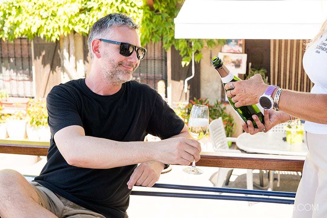 Man holding a champagne glass that is being filled by another person.