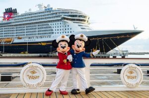 Captain Minnie and Mickey Mouse at the Disney Wish inauguration at Port Canaveral with the ship in the background.