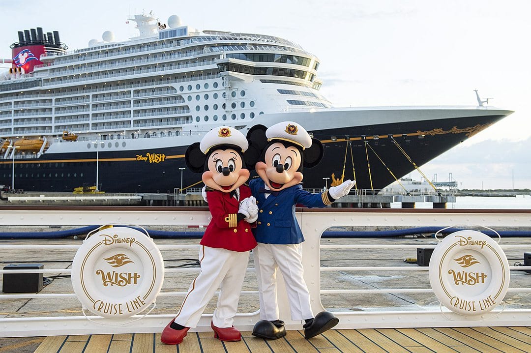 Captain Minnie and Mickey Mouse at the Disney Wish inauguration at Port Canaveral with the ship in the background.