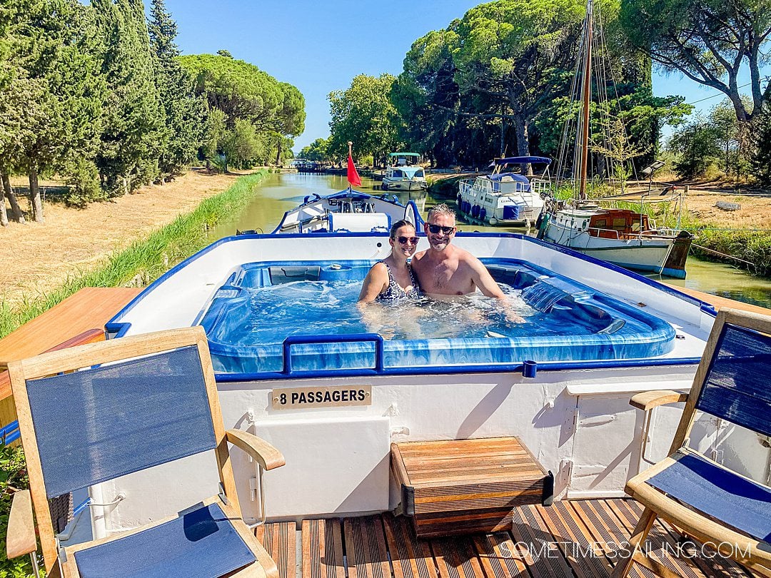 Couple in a hot tub spa on the bow of a luxury barge cruise ship.