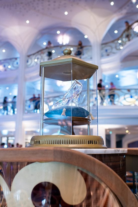 Cinderella's glass-encased glass slipper in the Grand Hall of Disney Wish cruise ship.