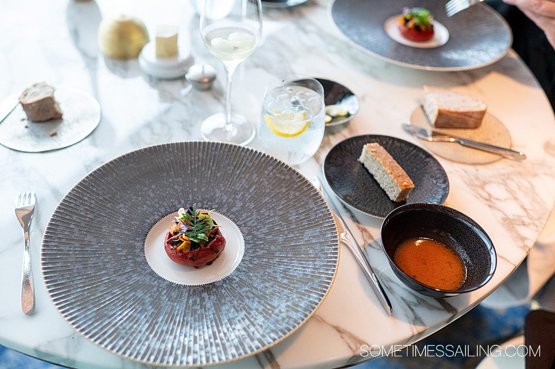 Tomato dish with flowers and a fern on top, on Disney Wish restaurant Enchante.