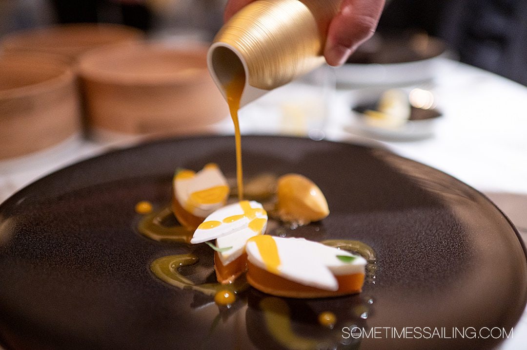 Apricot dessert with a sweet sauce being poured on top on Disney Wish.