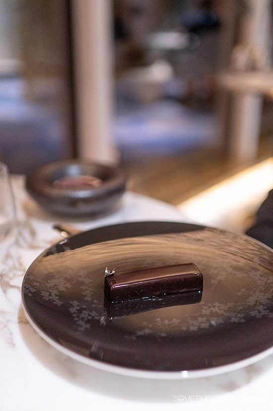 Rectangular pastry on a dark place, topped with glossy chocolate ganache at Enchante on Disney Wish.