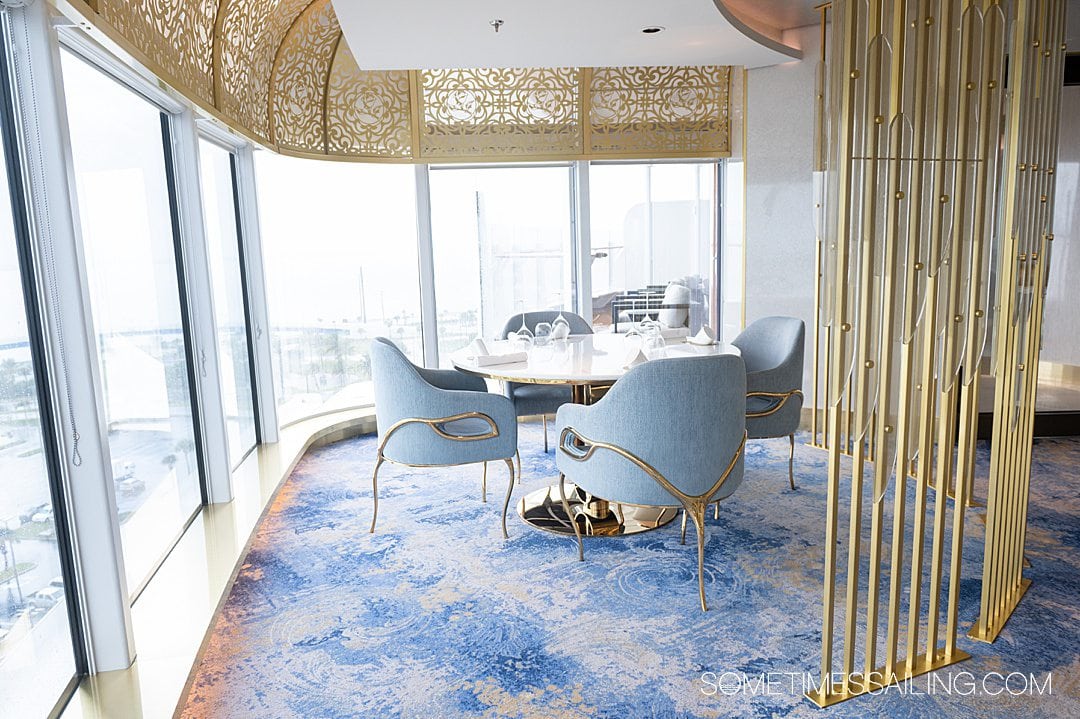 Interior of Enchante restaurant on Disney Wish cruise ship, with blue carpet and seats, and gold detailing.