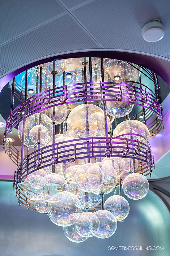 Disney Wish details in the chandelier of Nightingale's bar, with white handblown glass "bubbles" and music notes with hand-cut crystal centers.