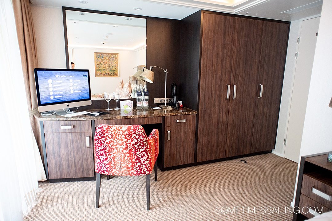 Dark wood closet and desk with a red chair on AmaKristina river cruise ship with AmaWaterways.