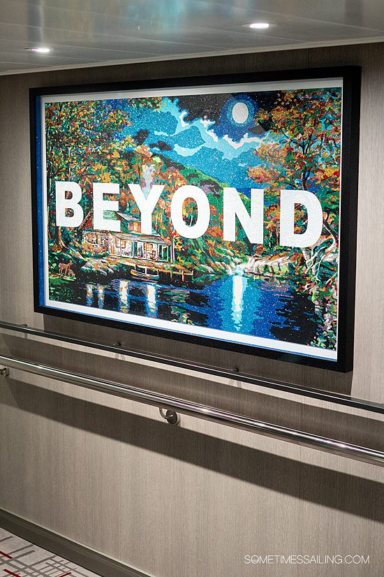 "BEYOND" letters in a glittery piece of art hung in the stairwell of Celebrity Beyond cruise ship.