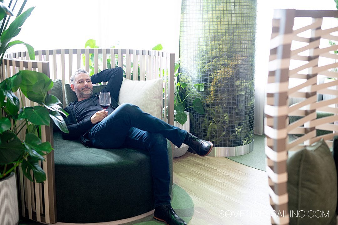 Man lounging in a rainforest type area on Celebrity Beyond cruise ship.