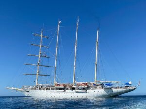 Star Clipper classic sailing cruise ship in the ocean with the sails down and masts sky-high.