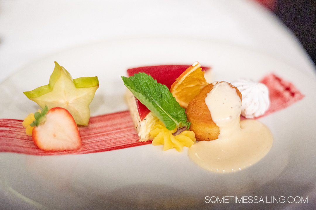 Plate of dessert with a slice of star fruit and schmear of red berry glaze on the plate for an AmaWaterways food review.