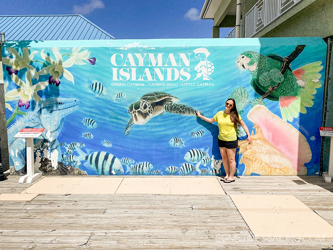 Woman in front of a Cayman Islands mural of the ocean during a cruise vacation.