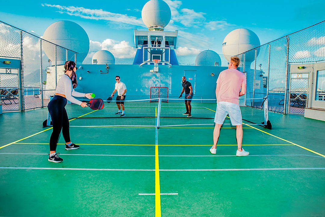 Pickleball players on a court on the top deck of a Celebrity Cruises ship.