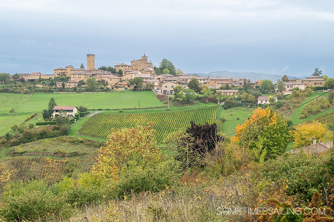 Looking out to a medieval town in France, called Oingt, on a misty blue-sky day.