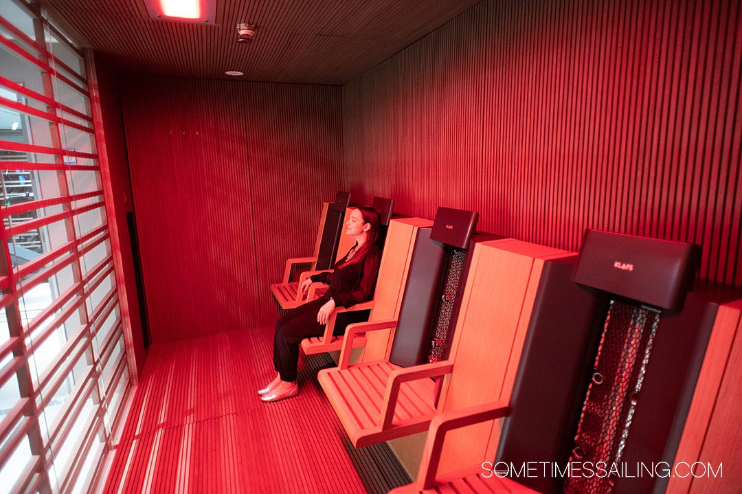 Woman sitting in a red room, which is an infrared sauna on Emerald Azzurra yacht cruise ship.