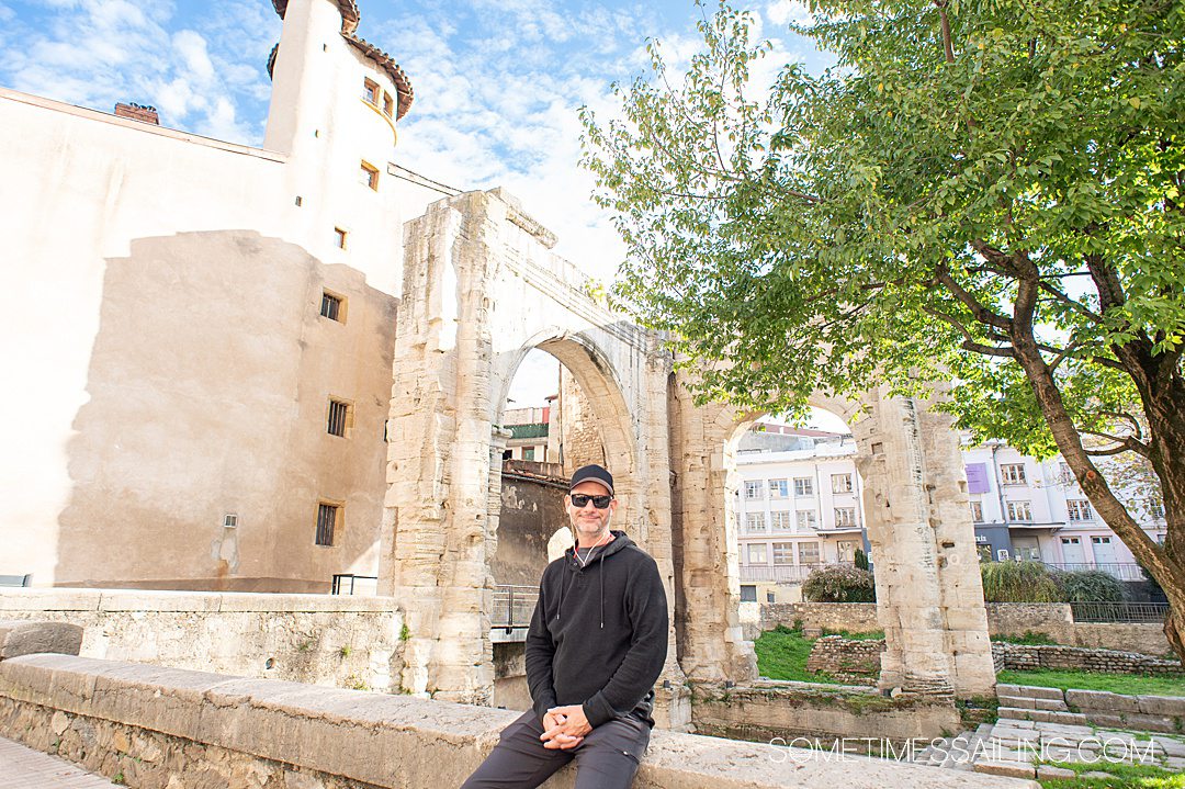 Man sitting in front of the Roman ruins in Vienne during a Provence excursion with AmaWaterways.