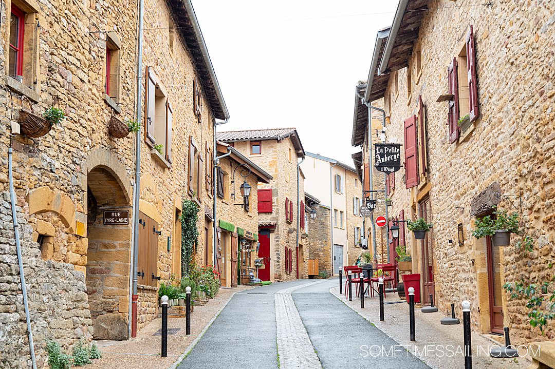 Golden limestone buildings lining a street in a quaint village named Oingt, in France's Beaujolais region.