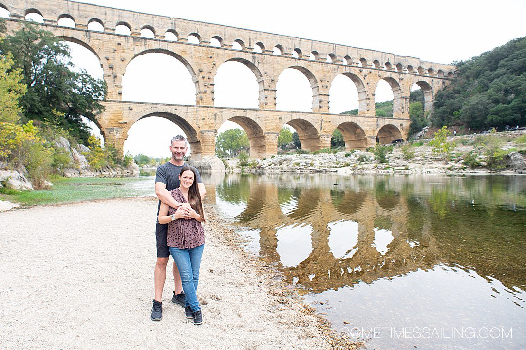 Couple in front of an aqueduct, Pont du Gard, in Nimes, France.