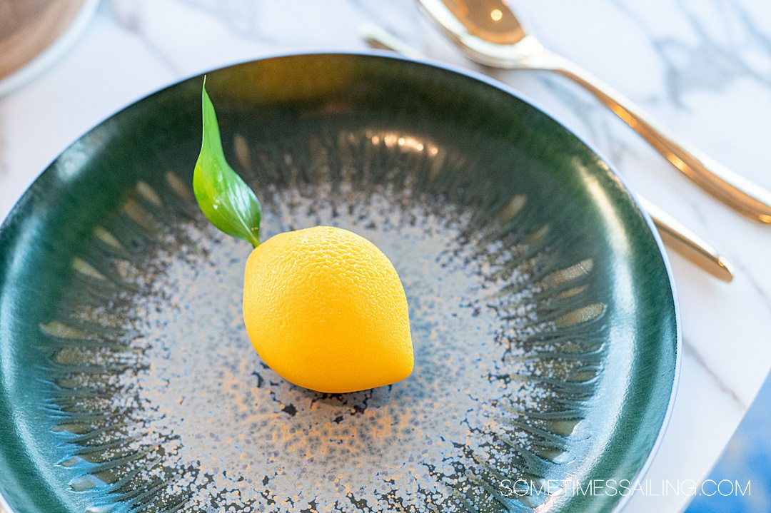 Teal round plate with a yellow lemon dessert in the middle.