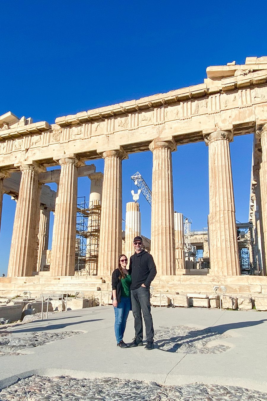 Couple standing in front of the Parthenon on the Acropolis in Athens, Greece.
