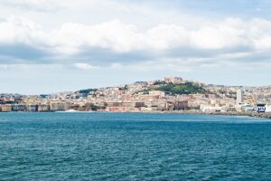 Naples in the distance the the ocean of the Gulf of Naples in the foreground approaching the cruise port of Naples.