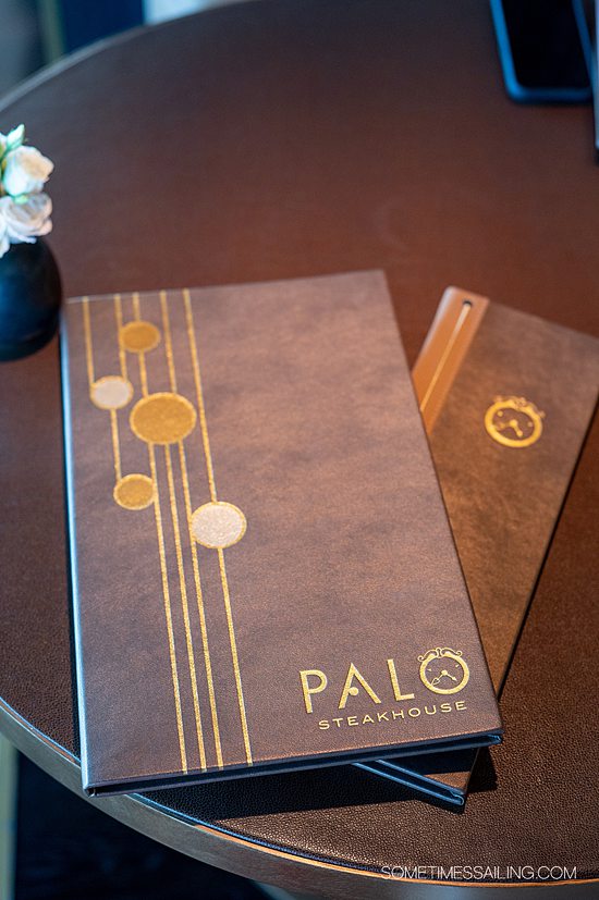 Brown and gold Palo restaurant menus on a table.