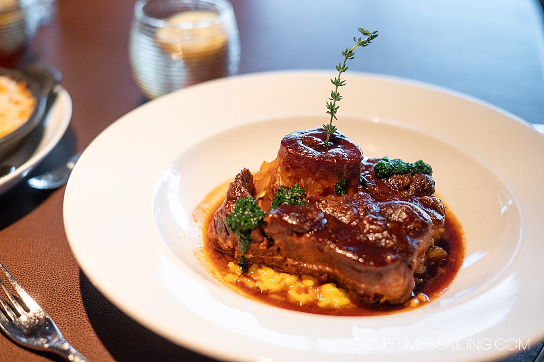 Osso Buco entree covered in sauce with Milanese risotto underneath at Palo restaurant on Disney Wish cruise ship.