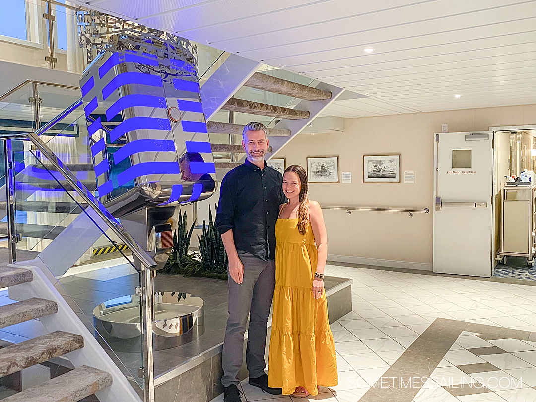 Couple standing by an oversized vintage microphone sculpture illuminated in blue lights on an American Cruise Lines river cruise ship sailing the Tennessee River.