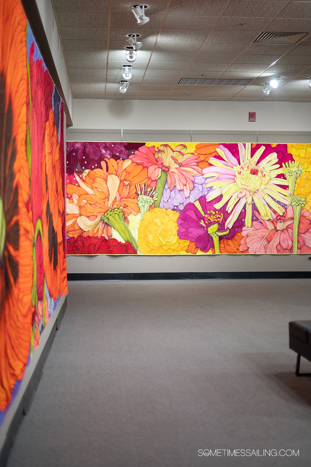 Colorful modern quilts with flowers in orange and yellow with pops of pink and purple at the National Quilt Museum.