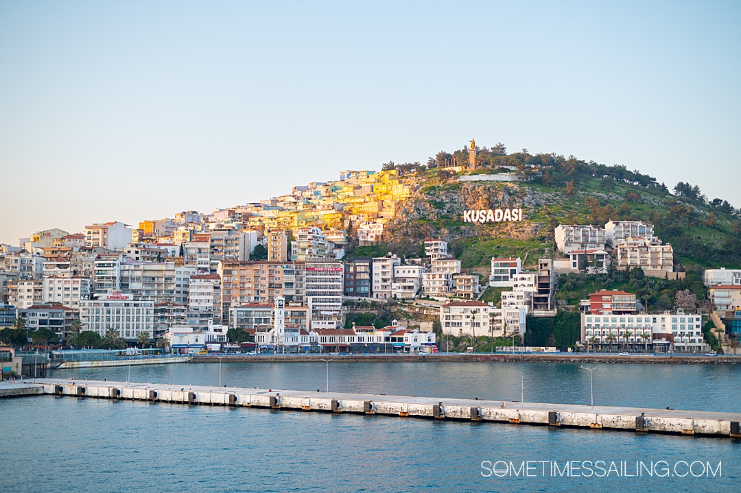 Looking from the water to a hill of Kusadasi, Turkey with homes on the hillside.
