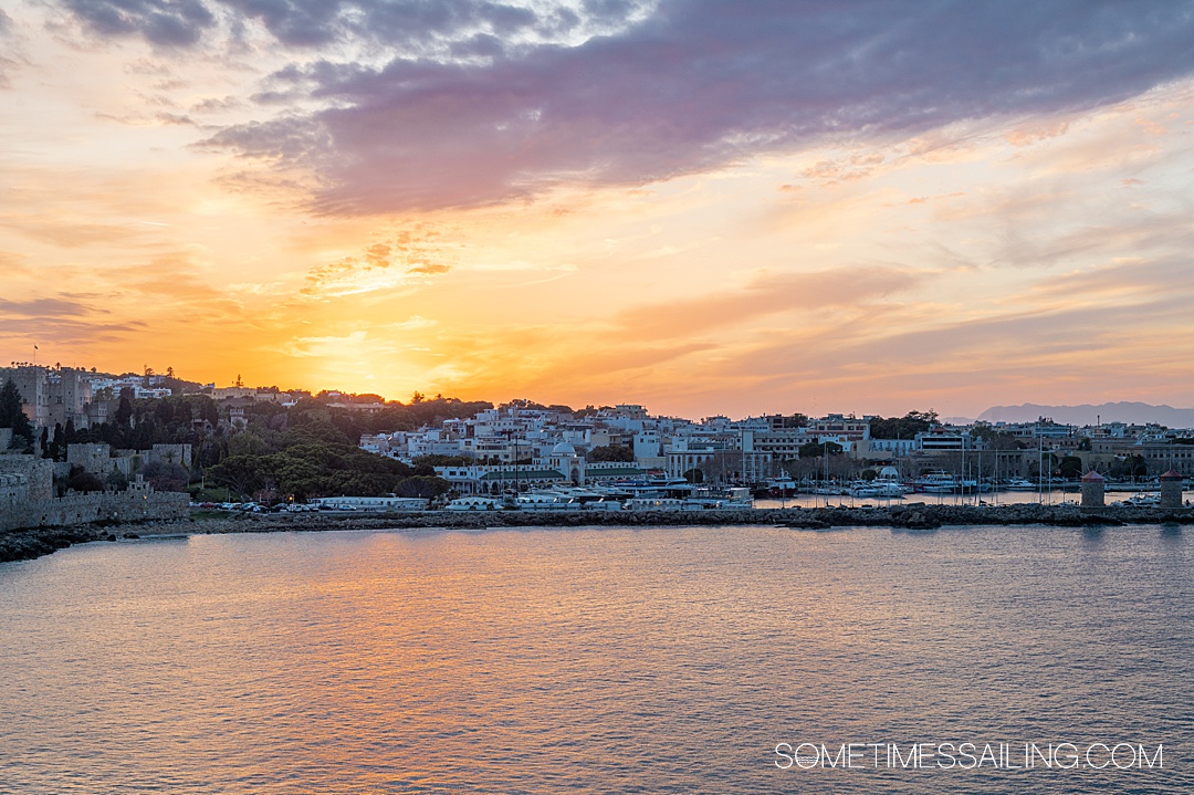 Sunset over a waterfront view of Rhodes, Greece, during a Celestyal Cruises Three Continents cruise.