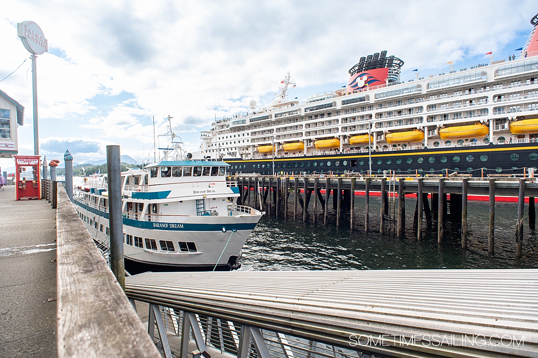 A small cruise ship on the left and a large Disney cruise ship on the right in a cruise port in Ketchikan, Alaska.