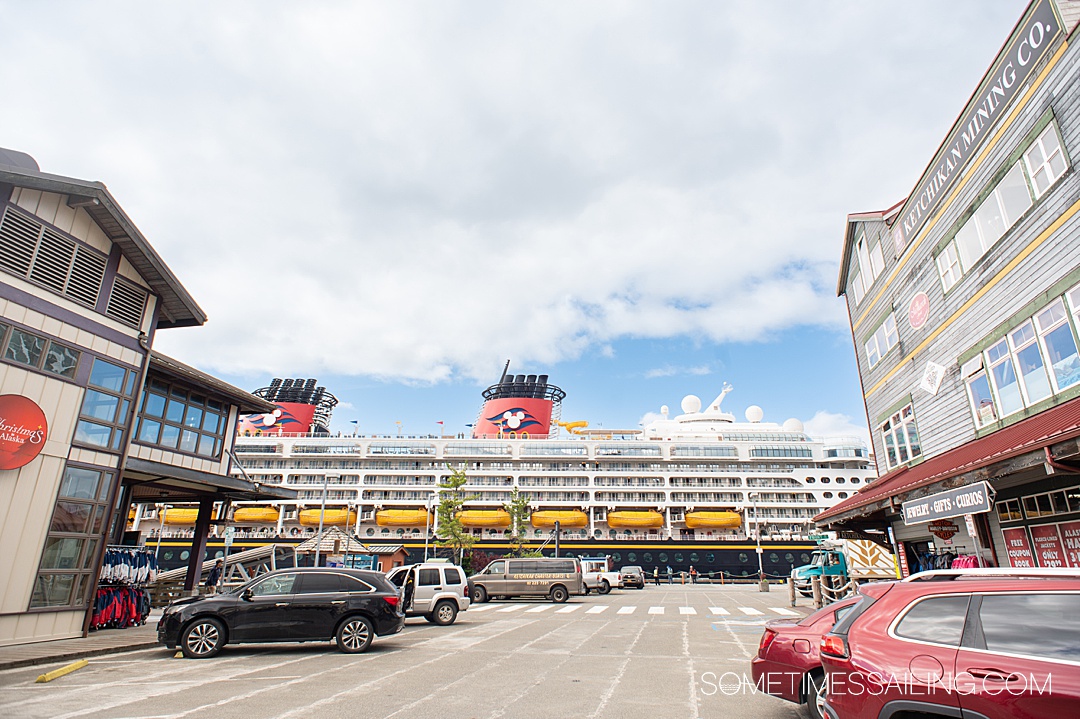 Disney Cruise Line in the distance with a street in front of the ship and buildings on either side in Alaska.